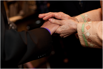 Her Majesty holds the hand of a recent patient